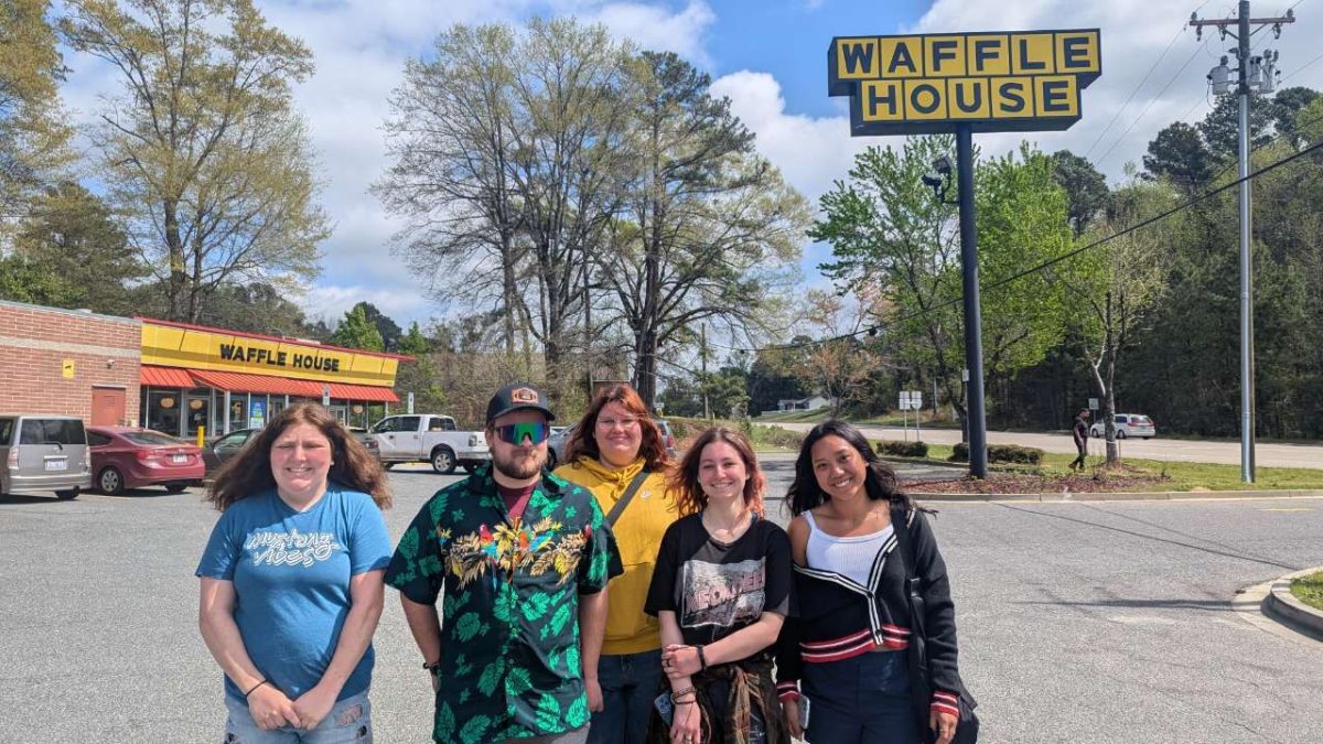 Speech team posing in front Waffle House 